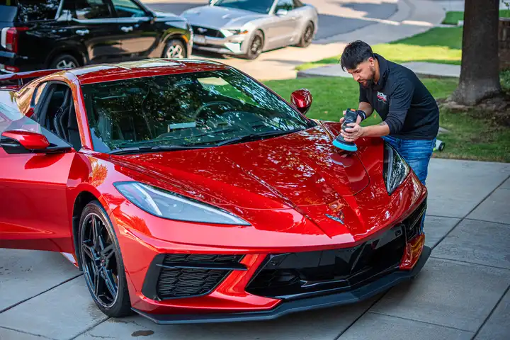 Machine polishing a red Corvette during paint correction by Forge Auto Studio in Denver